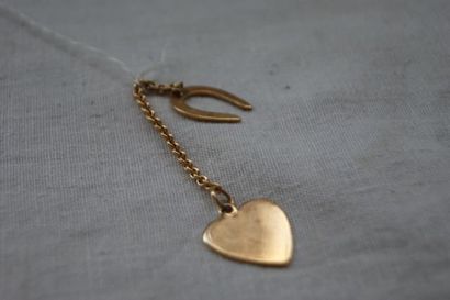 null Chaînette en or 14K, ornée de deux breloques : une en forme de coeur, l'autre...