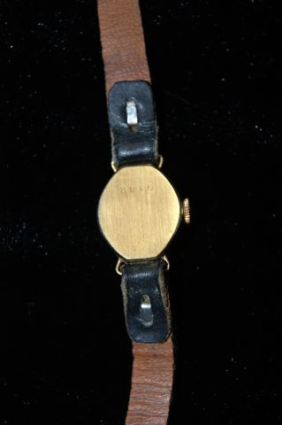 null Montre de dame en or jaune, bracelet en cuir noir (usé). Poids brut : 8,49 ...