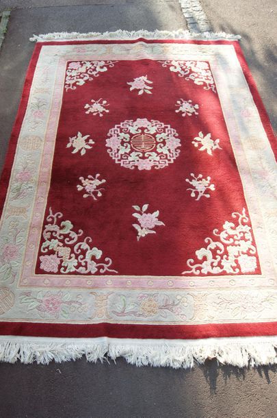 null CHINE Tapis en laine à décor floral sur fond bordeaux. 210 x 285 cm