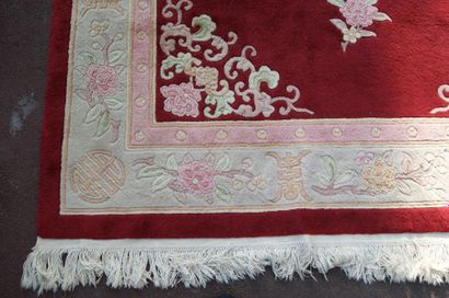 null CHINE Tapis en laine à décor floral sur fond bordeaux. 210 x 285 cm