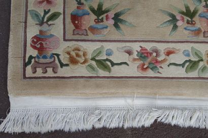 null CHINE Tapis en laine à décor floral sur fond beige.