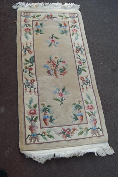null CHINE Tapis en laine à décor floral sur fond beige.  163 x 70 cm