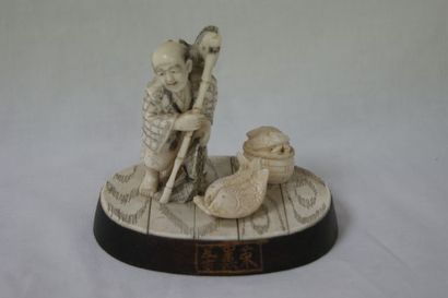 null CHINE Groupe en ivoire, figurant un pêcheur. Socle en bois. 9 x 10 cm