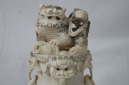 null CHINE Pot tripode en ivoire sculpté, surmonté d'un chien de fô. 31 cm Sur son...