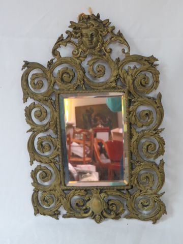 null Petit miroir en bronze à décor de rinceaux et d'un mascaron. 38 X25 cm