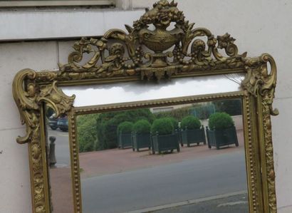 null Miroir à parecloses en bois doré et stuqué à décor de rinceau et volutes , couronné...