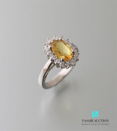 null Bague en or blanc 750 millièmes, sertie en son centre d'un saphir jaune taille...