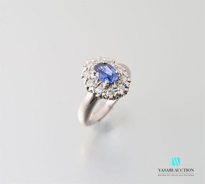 null Ring in 750-thousandths white gold set with a central oval sapphire surrounded...
