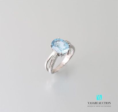 null White gold ring adorned in its center with an oval cut topaz calibrating approximately...