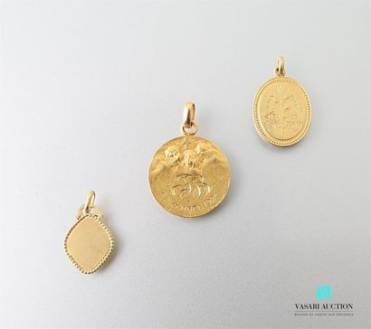 null Three medals in 750 thousandths yellow gold, one with cherubs surrounding a...