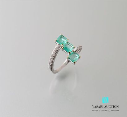 null White gold ring with offset ring decorated with three emerald-sized emeralds...