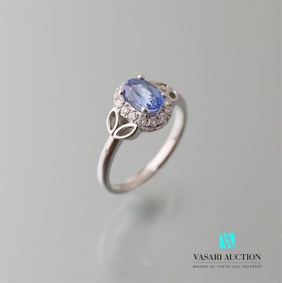 null White gold ring adorned in its centre with an oval sapphire calibrating approximately...
