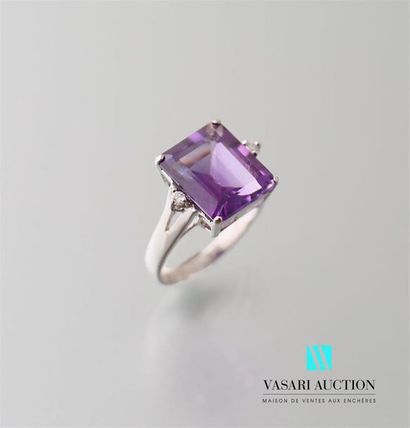 null White gold ring adorned in its centre with an emerald-cut amethyst calibrating...