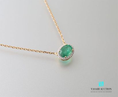 null Pendant and its yellow gold chain adorned in its center with an oval cut emerald...