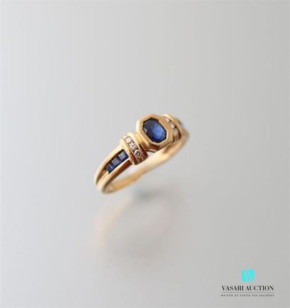 null 750-thousandths yellow gold ring centred on an oval sapphire with three small...