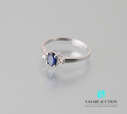 null Ring in 750-thousandths white gold adorned with an oval sapphire with diamonds...