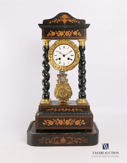 null A blackened wooden clock, the round enamelled dial is adorned with an acanthus...