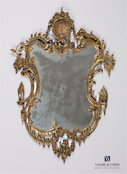 null Mirror in varnished bronze of free form, it is summoned of a shell topped with...