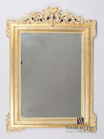 null A moulded and carved wooden mirror, painted in gold, with a frieze of water...