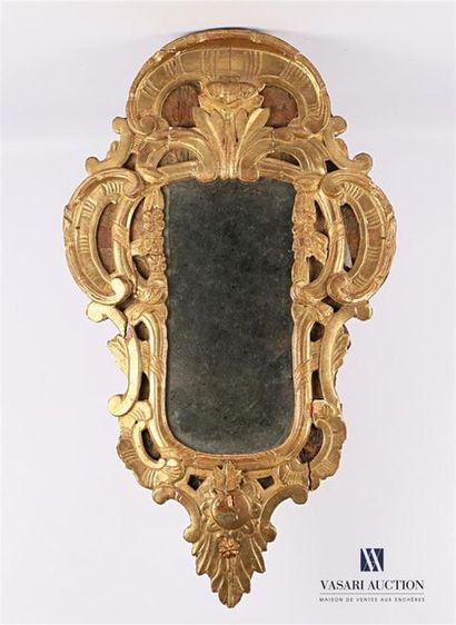 null Moulded, carved and gilded wood mirror with a moving shape decorated with scrolls...