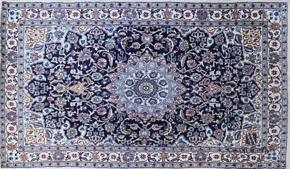null IRAN - NAIN 
Woollen rug decorated with a central radiating medallion in a circle...