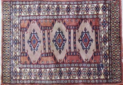 null PAKISTAN
Wool bedside rug decorated with three central medallions on a brown
background...