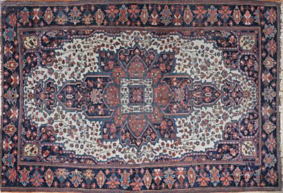 null IRAN - Sarouk 
Tapis en laine à décor à décor d'un large motif central sur fond...