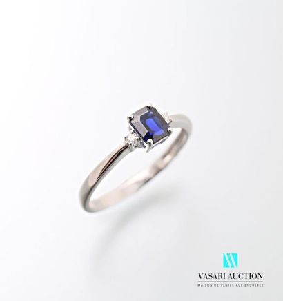 null 750 thousandths white gold ring adorned with an emerald-cut sapphire calibrating...