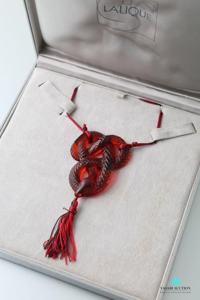 null LALIQUE
Red crystal snake pendant supported by a cord and holding a pompom in...
