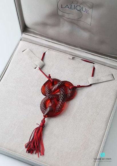 null LALIQUE
Pendentif serpent en cristal rouge soutenu par un cordon et tenant un...