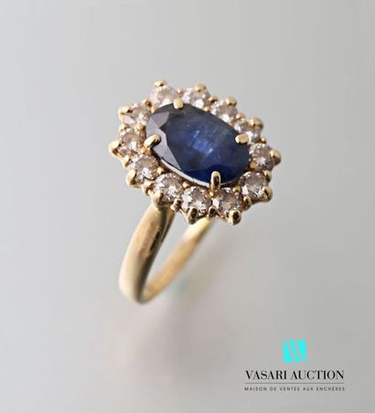 null Yellow gold ring 750 thousandths set with a central oval sapphire surrounded...