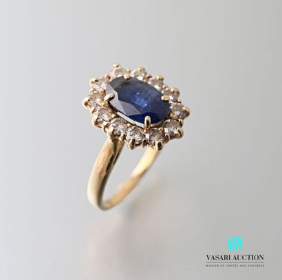 null Yellow gold ring 750 thousandths set with a central oval sapphire surrounded...