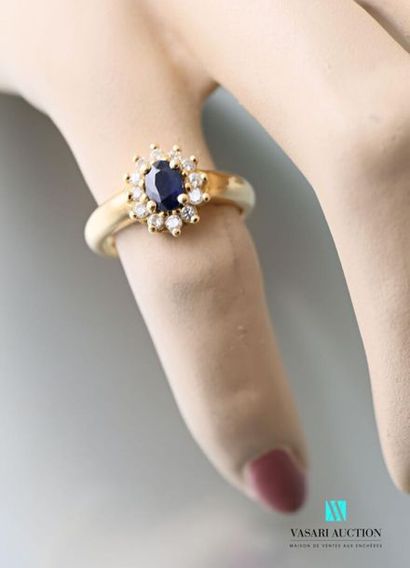 null Daisy ring in yellow gold 750 thousandths set with a central sapphire surrounded...