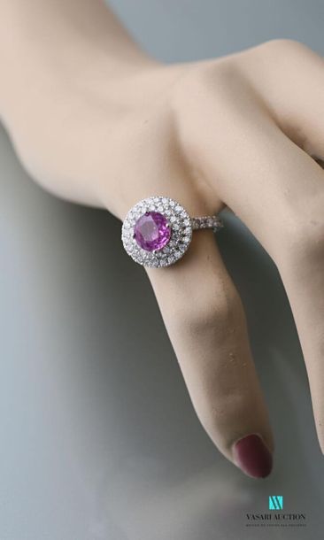 null Round ring in 750 thousandths gold centered on a round-cut pink sapphire calibrating...