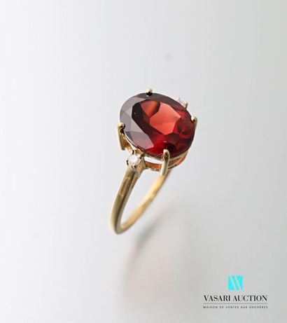 null Vermilion ring centered of an oval cut garnet with two diamonds. 
Gross weight:...