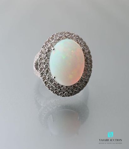 null Ring in 750 thousandths gold centered on a cabochon cut opal hemmed with a double...