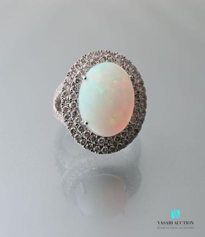 null Bague en or 750 millièmes centrée d'une opale de taille cabochon ourlée d'une...