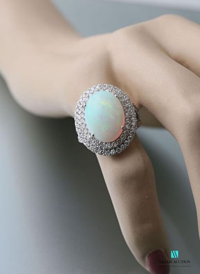 null Bague en or 750 millièmes centrée d'une opale de taille cabochon ourlée d'une...