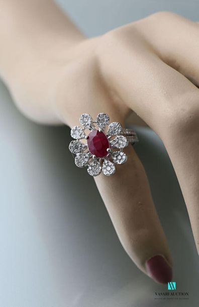 null 750 thousandths gold ring in the shape of a daisy, the heart set with a ruby...