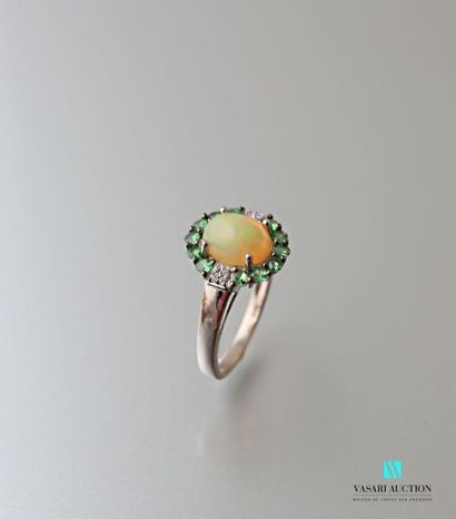 null Bague en argent centrée d'une opale de taille cabochon ourlée de Tsavorites.
Poids...