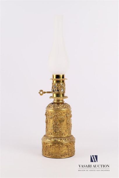 null Oil lamp in repoussé brass, the base decorated with eventful reserves decorated...