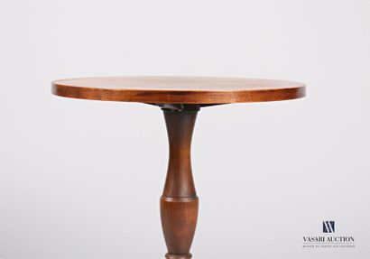  Pedestal table in stained natural wood, the round top rests on a baluster shaft...