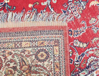 null Mechanical carpet with red background decorated with scrolls and floral
motifs...