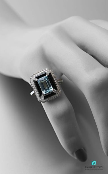 null A 750 thousandths white gold ring adorned in its centre with an emerald-cut...