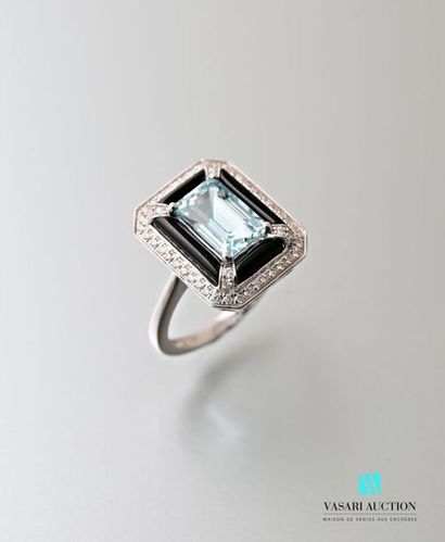 null A 750 thousandths white gold ring adorned in its centre with an emerald-cut...