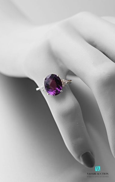 null 750 thousandths white gold ring set with an oval-shaped amethyst calibrating...