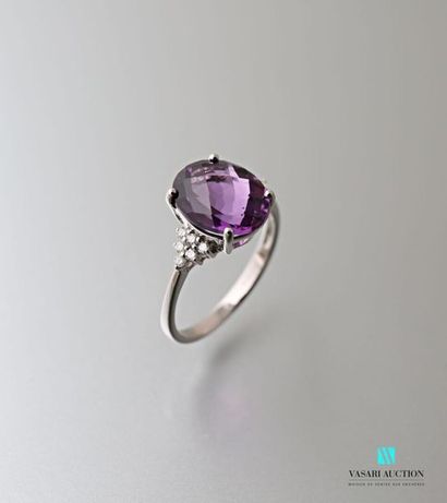 null 750 thousandths white gold ring set with an oval-shaped amethyst calibrating...