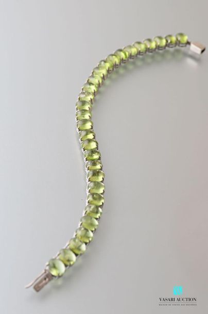 null Silver bracelet decorated with peridot cabochons, clip-clasp with safety eights.

Length...