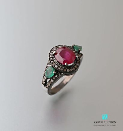 null Patina silver ring centered on an oval cut ruby with two pear cut emeralds and...