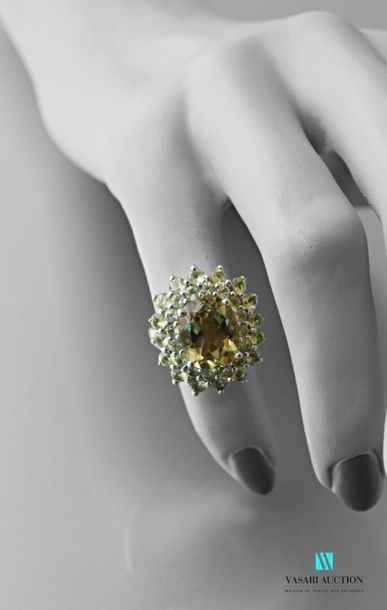 null Silver ring set with an oval quartz lemon in a double green stone surround Gross
weight:...
